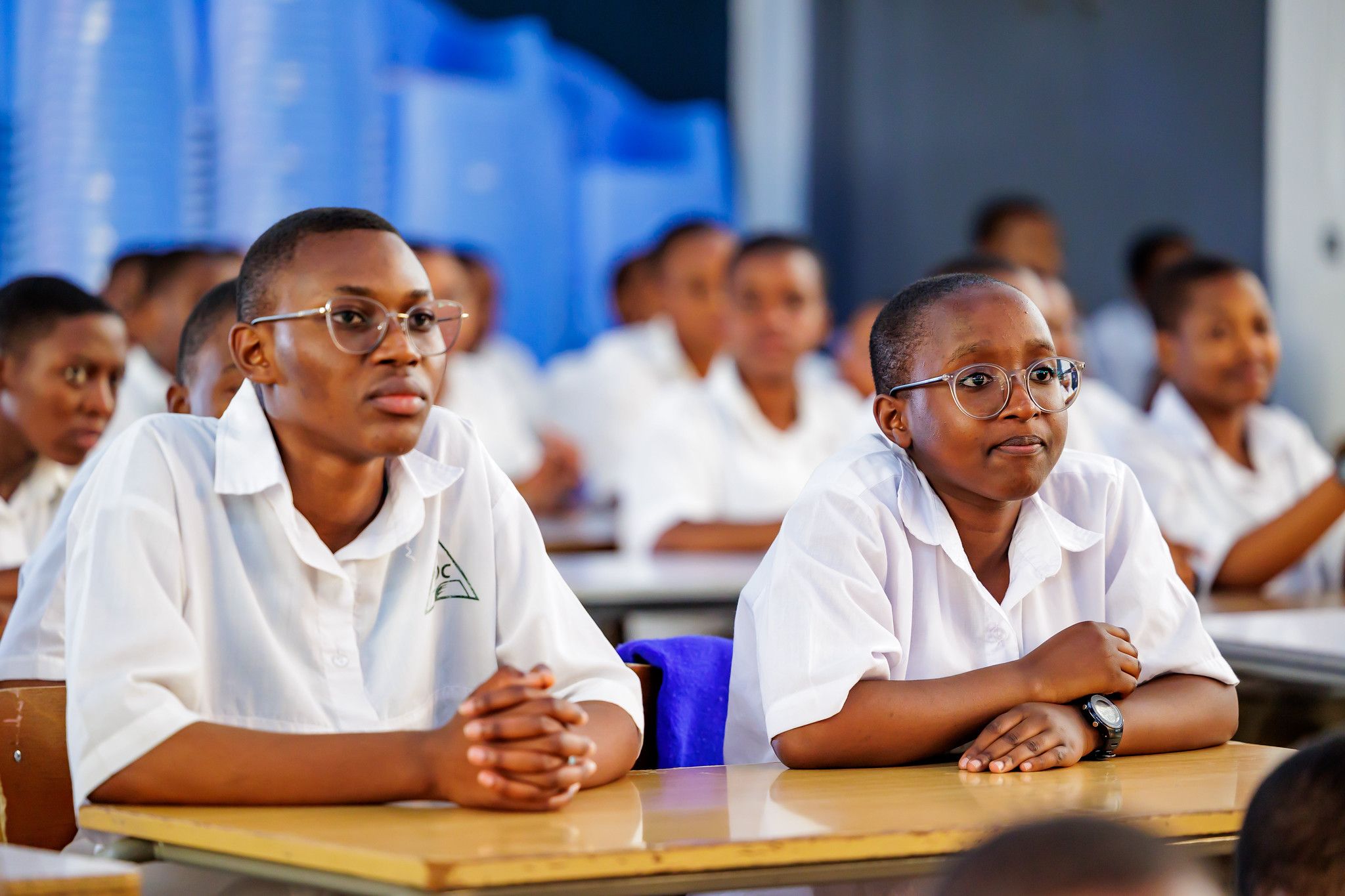 Students seated in rows, smiling towards the stage