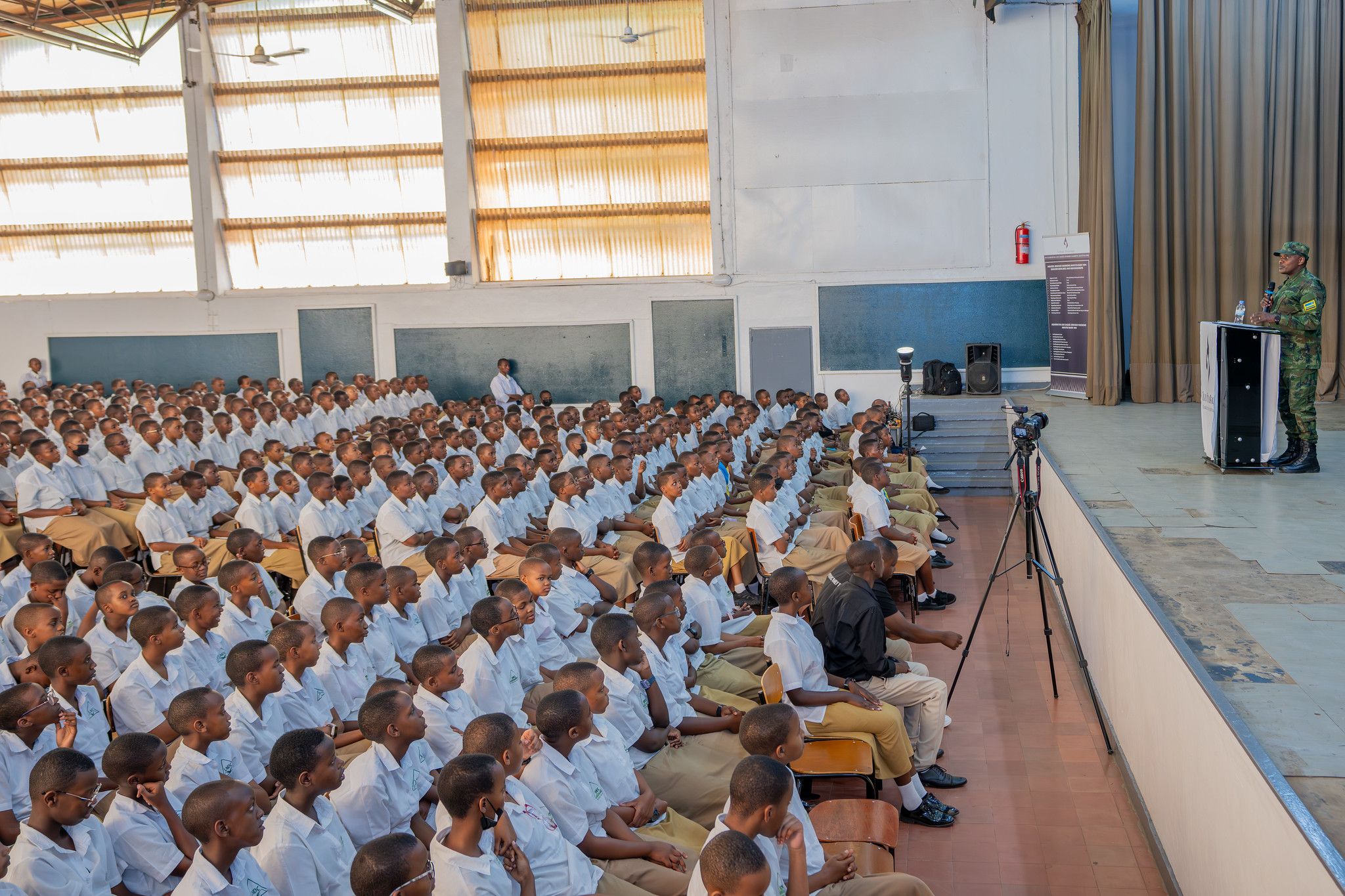 Students listen as the Rwanda Defence Force spokesperson speaks from the stage